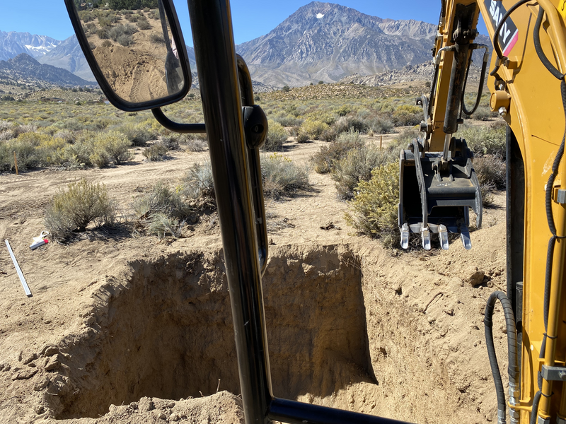 A view of the partially completed septic tank hole from the cab of the mini-excavator