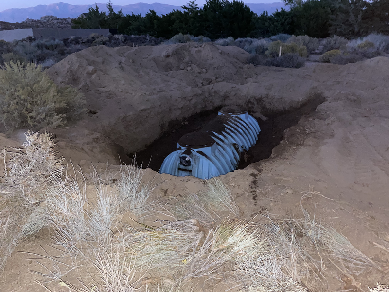 A half buried blue septic tank at dusk