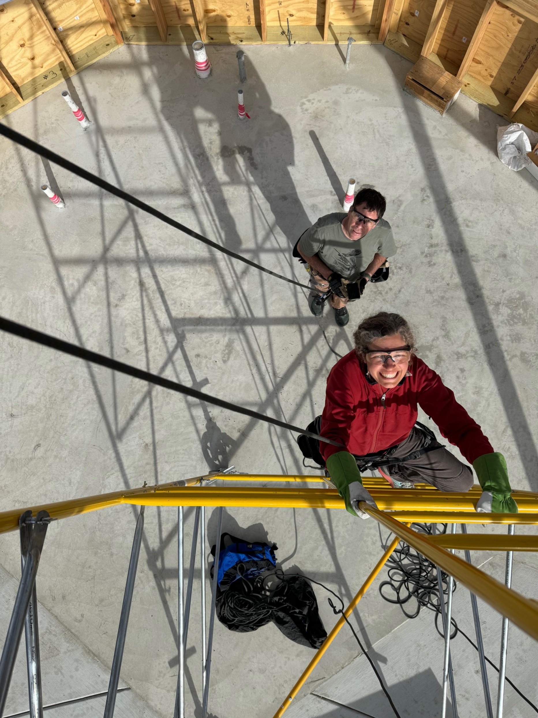 A woman climbs up scaffolding