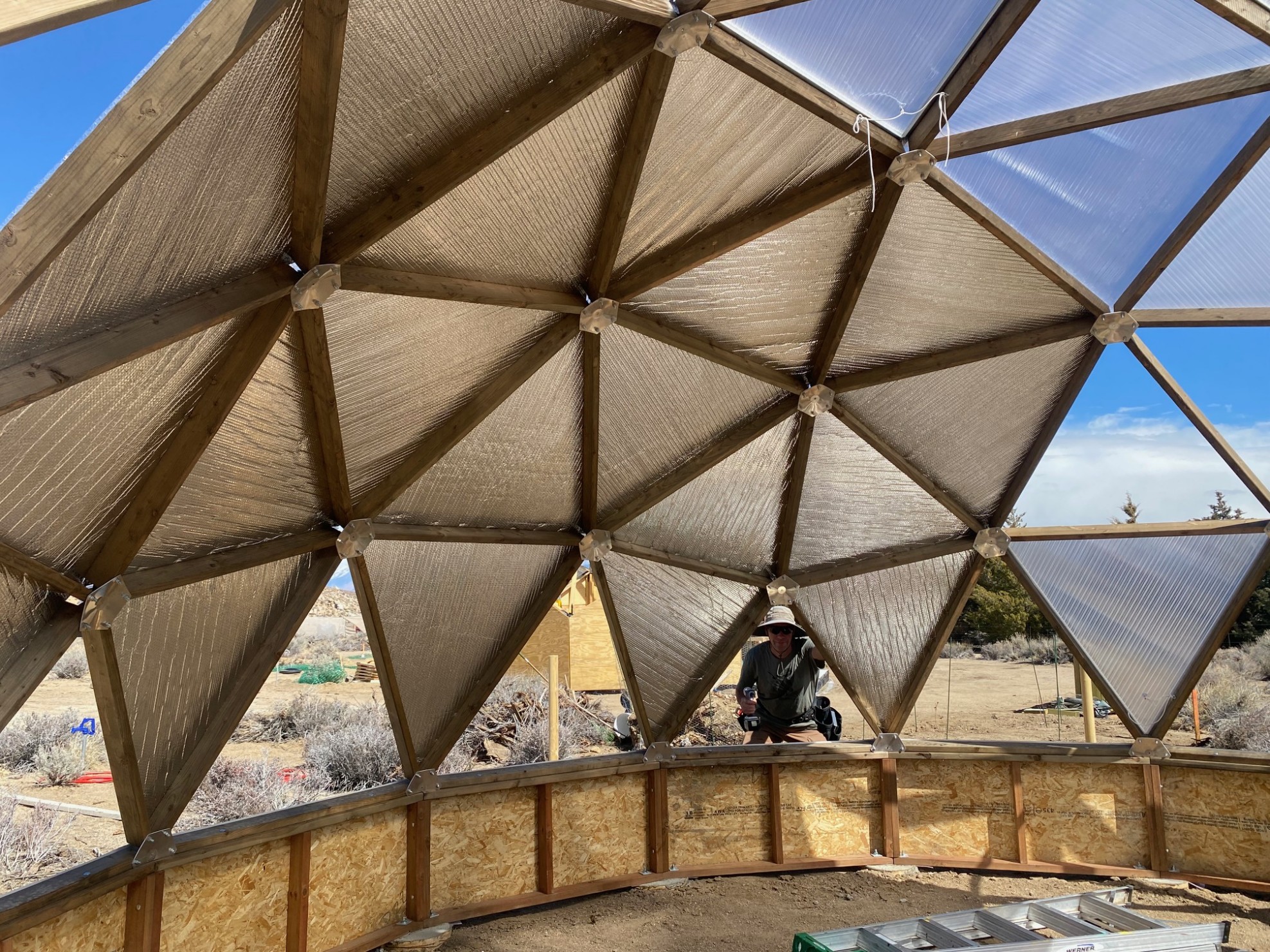 A man looking through an open triangle in a dome. Most triangle shown have reflectix on them