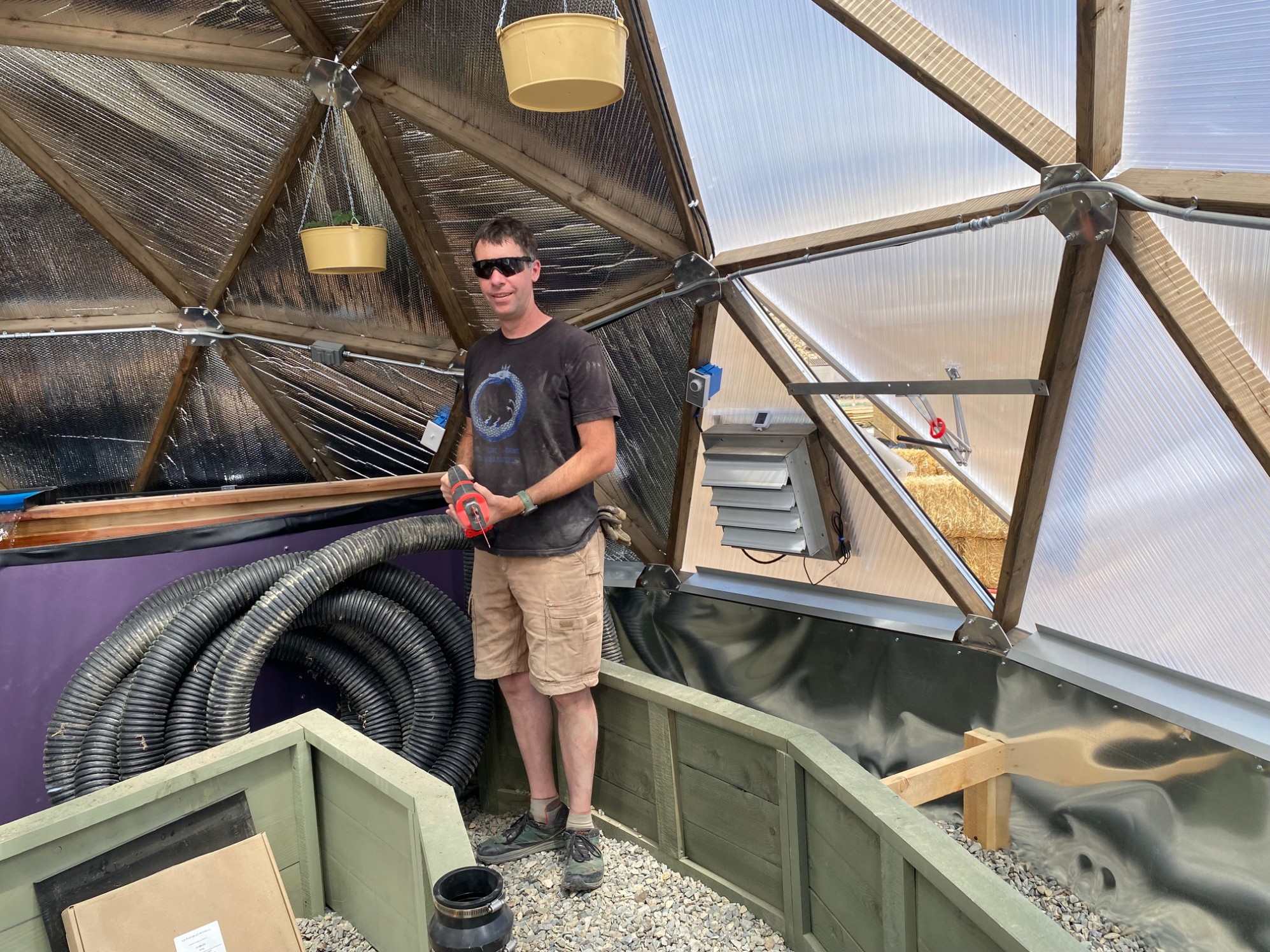 A man with a saw near a coil of storm pipe