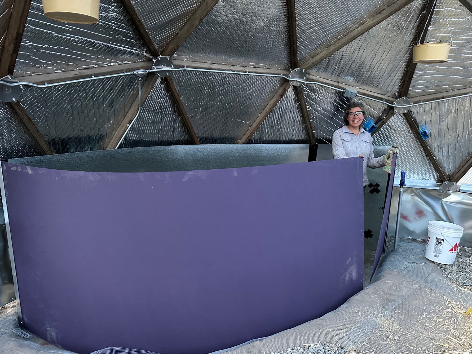 A woman posing inside a partially completed indoor pond