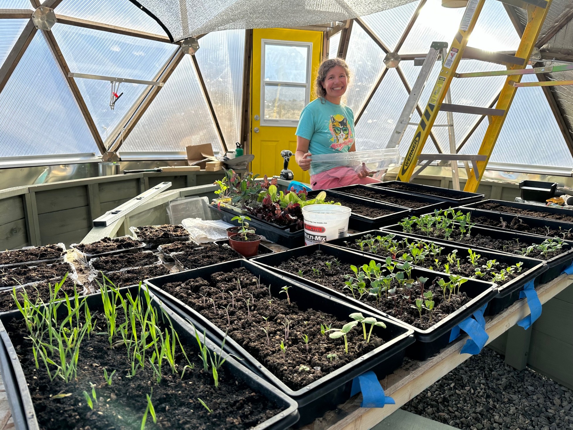 A woman smiling by her seedlings