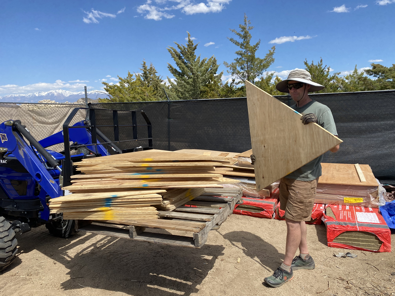 Man holds triangle of plywood