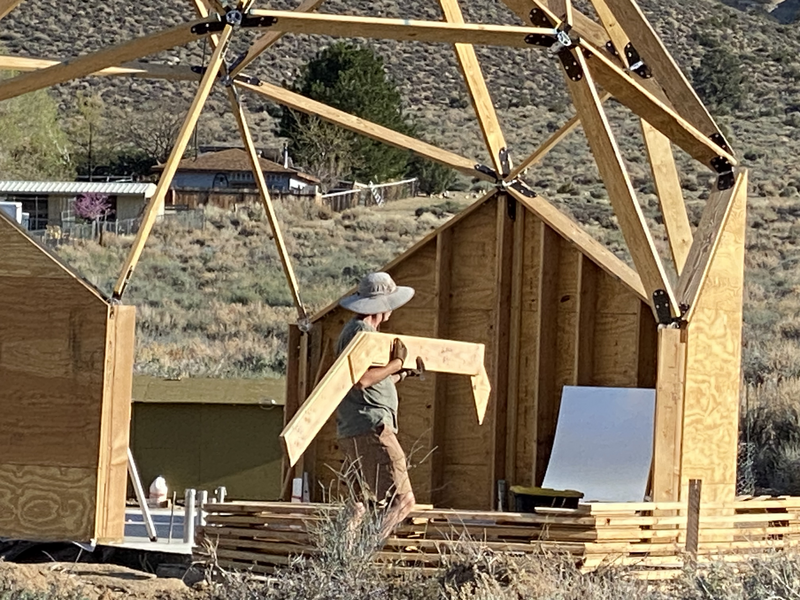 A man carrying a 3 member section of a dome extension arch