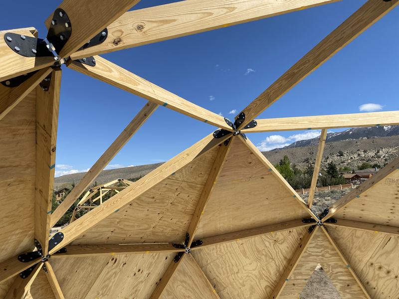 triangles of geodesic dome, some with an extra 2x4 attached, bisecting a triangle