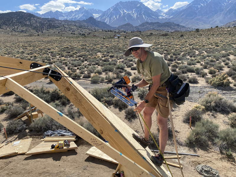 man using air nailer on geodesic dome