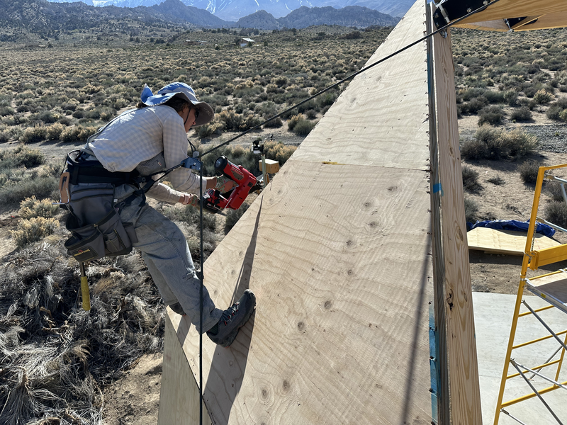 woman using cordless nail gun on geodesic dome