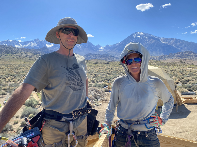 2 people smiling at top of geodesic dome