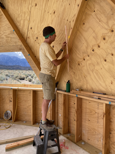 man using string, a yard stick, a step stool, and his mind to picture the angles of the wall