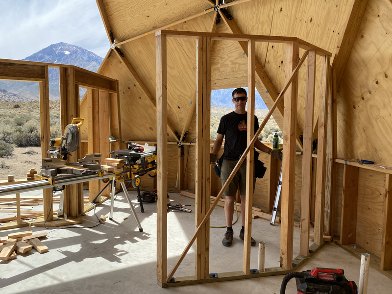 a man seen through 2 angled framed walls