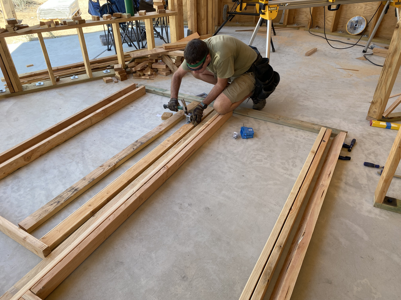 a man installing an electrical box in a partially framed wall