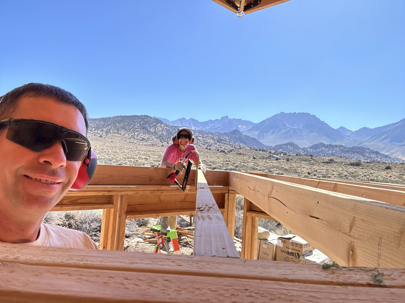 a selfie with another person working on joists